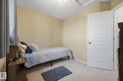 Room featuring light beige walls, neutral carpet flooring, and a white paneled interior door - 60 Leyland Way, Spruce Grove, AB 