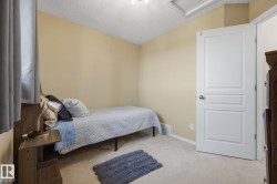 Room featuring light beige walls, neutral carpet flooring, and a white paneled interior door - 