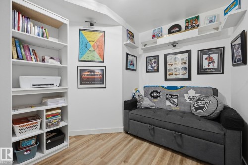 Inviting interior space featuring wood-finish flooring, white walls, and built-in shelving - 60 Leyland Way, Spruce Grove, AB 