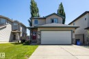 Two-story residence featuring light-colored siding, a dark roof, and a red front door - 60 Leyland Way, Spruce Grove, AB 