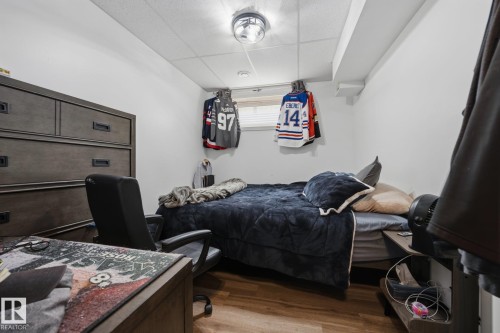 Room featuring wood-finish flooring, a neutral wall palette, and a drop-ceiling - 60 Leyland Way, Spruce Grove, AB 