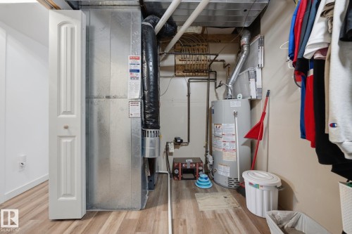 Utility area with wood-finish flooring, a water heater, and a furnace unit - 60 Leyland Way, Spruce Grove, AB 