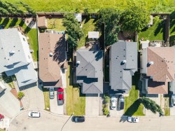 Aerial depiction of a residential street featuring multiple homes with distinct rooflines and private driveways - 