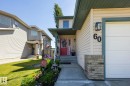 Cream-colored siding facade with a contrasting dark green soffit and trim - 60 Leyland Way, Spruce Grove, AB 