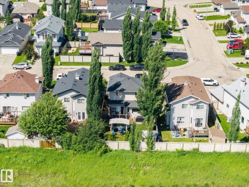 Residential property featuring a light-colored exterior, an asphalt shingle roof, and multiple windows - 60 Leyland Way, Spruce Grove, AB 