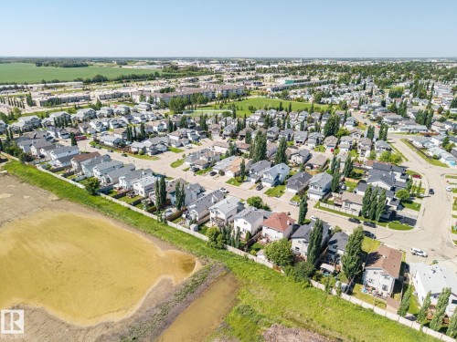 Aerial perspective of a residential neighborhood featuring detached homes with varied rooflines and a mix of mature and young trees - 60 Leyland Way, Spruce Grove, AB 