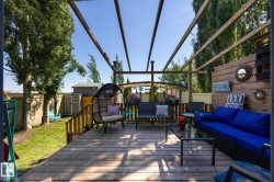Expansive wood deck with a slatted pergola overhead - 