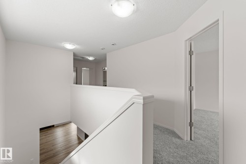 Upper-level landing featuring a white railing and neutral wall tones - 12523 171 Avenue, Edmonton, AB 