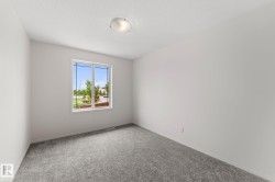 Bright interior room with grey carpeting and white walls - 