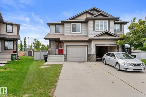 Two-story residence featuring light gray siding, stone accents, and dark trim - 12523 171 Avenue, Edmonton, AB 