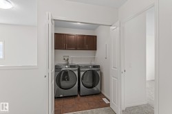Dedicated laundry closet featuring a tile floor, built-in cabinetry, and a full-size washer and dryer - 