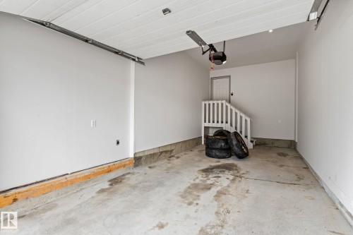 Spacious garage featuring a concrete floor, painted walls, and an overhead garage door opener mechanism - 12523 171 Avenue, Edmonton, AB 