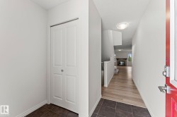Entryway featuring dark tile flooring, a red entry door, and a bi-fold closet - 