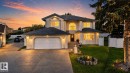 Two-story residence featuring a stucco exterior, attached two-car garage, arched entry window, front lawn with landscaping, and a paved driveway - 4615 43A Avenue, Edmonton, AB  - Outdoor 