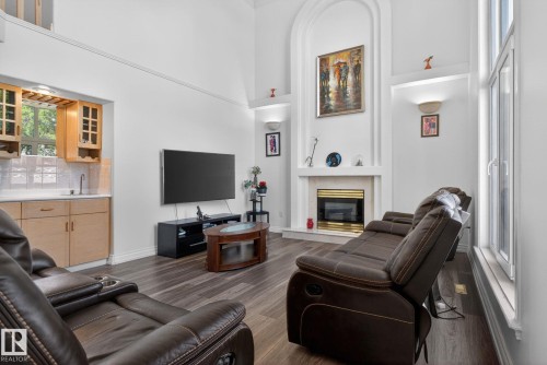 Spacious living area featuring high vaulted ceilings, wood-finish flooring, and a fireplace with a decorative mantel - 4615 43A Avenue, Edmonton, AB - Indoor Photo Showing Living Room With Fireplace