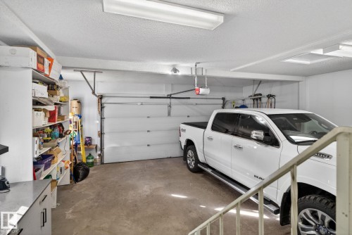 Attached garage with concrete flooring, automatic garage door opener, and overhead fluorescent lighting - 4615 43A Avenue, Edmonton, AB - Indoor Photo Showing Garage