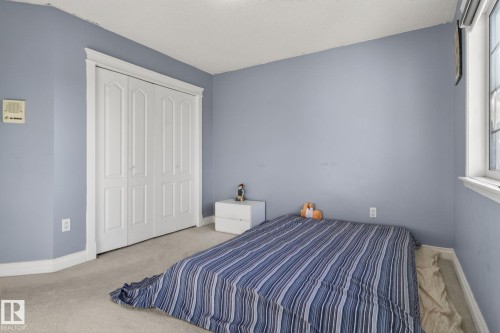 Bedroom featuring light blue walls, white trim, and light-colored carpet - 4615 43A Avenue, Edmonton, AB - Indoor Photo Showing Bedroom