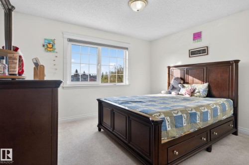 Carpeted bedroom with neutral wall paint, white trim, and a multi-pane window - 4615 43A Avenue, Edmonton, AB - Indoor Photo Showing Bedroom