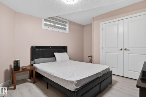 Bedroom with light wood-finish flooring, a white trim baseboard, and a white ceiling - 4615 43A Avenue, Edmonton, AB - Indoor Photo Showing Bedroom