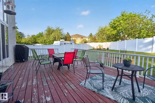 Spacious wood-finish deck with white railing, overlooking a fenced backyard with mature trees - 4615 43A Avenue, Edmonton, AB - Outdoor With Deck Patio Veranda With Exterior