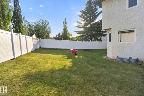 Expansive backyard featuring a green lawn, full perimeter white privacy fencing, and mature trees - 4615 43A Avenue, Edmonton, AB - Outdoor