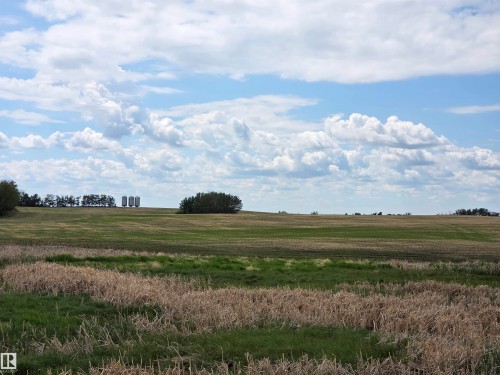 Expansive agricultural landscape featuring open fields and distant structures - 24209 Hwy 625, Beaumont, AB 