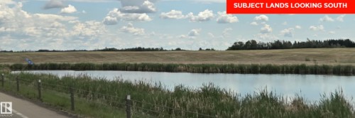 Expansive land featuring a tranquil pond, natural wetland vegetation, and a distant treeline - 24209 Hwy 625, Beaumont, AB 