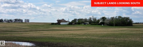 Expansive agricultural land featuring a modest dwelling, multiple outbuildings, and scattered trees - 24209 Hwy 625, Beaumont, AB 
