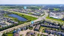 Aerial perspective showcasing a residential community with varied architectural styles and a prominent central pond - 46 15151 43 Street, Edmonton, AB 