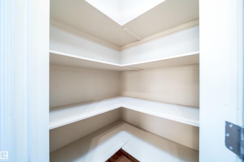 Corner pantry with multiple white shelves and wood-finish flooring - 46 15151 43 Street, Edmonton, AB 