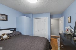 Bedroom featuring wood-finish flooring, a bi-fold closet door, and light blue wall paint - 