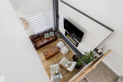 Living area with light wood-finish flooring and a contemporary fireplace feature wall - 