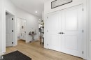 Entryway featuring wood-finish flooring, recessed lighting, and a double-door closet with matte black hardware - 7 Tenor Link, Spruce Grove, AB 