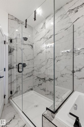Spacious walk-in shower with clear glass enclosure and matte black hardware - 7 Tenor Link, Spruce Grove, AB 