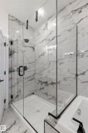 Spacious walk-in shower with clear glass enclosure and matte black hardware - 