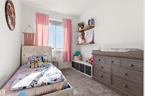 Bedroom featuring a large window, neutral wall paint, gray carpet, and floating shelves - 7 Tenor Link, Spruce Grove, AB 