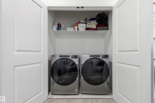 Dedicated laundry closet featuring a built-in shelf and tile flooring - 7 Tenor Link, Spruce Grove, AB 