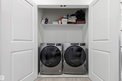 Dedicated laundry closet featuring a built-in shelf and tile flooring - 