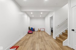 Spacious open area featuring wood-finish flooring, recessed lighting, and a neutral color palette - 