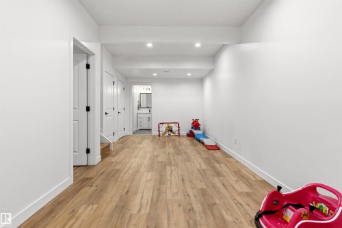 Spacious room featuring wood-finish flooring, recessed lighting, and bright white walls - 7 Tenor Link, Spruce Grove, AB 