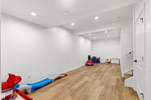 Spacious room featuring wood-finish flooring, recessed lighting, white walls, and white trim - 7 Tenor Link, Spruce Grove, AB 