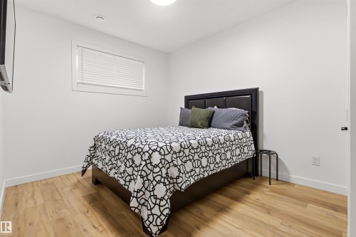 Bedroom featuring wood-finish flooring, white walls, and a window with blinds - 7 Tenor Link, Spruce Grove, AB 