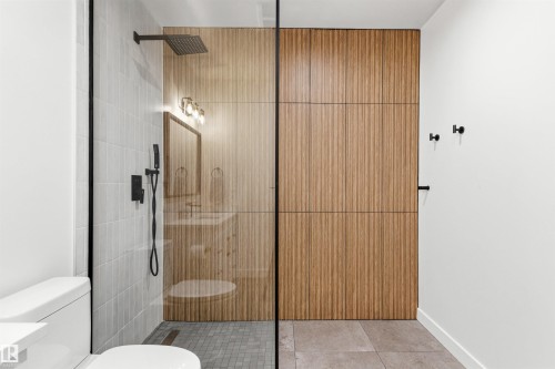 Glass-enclosed shower with a matte black rain shower head and handheld sprayer - 7 Tenor Link, Spruce Grove, AB 