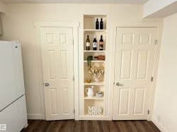 Built-in shelving unit with multiple display levels flanked by two panel doors - 