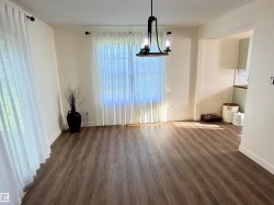 Open-concept living space featuring wood-finish flooring and neutral-toned walls - 