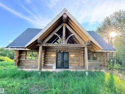 Log cabin exterior featuring a prominent gabled roofline and exposed timber framing - 