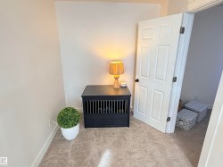Carpeted room with a five-panel interior door, baseboard molding, and neutral wall tones - 