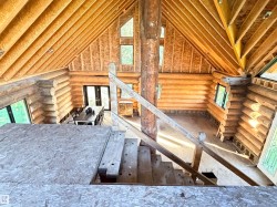 Log construction interior with exposed wood beam ceilings and a prominent central log column - 