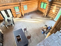 Spacious open-concept interior featuring prominent log wall construction - 