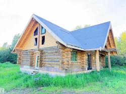 Log cabin architecture with an unfinished roof and exposed OSB gable ends - 